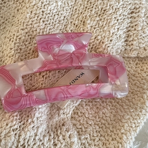 Detail view of pink marble acetate hair claw with France Handmade engraving and brand tag