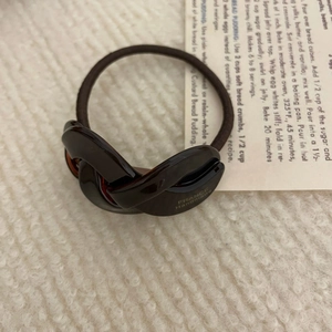 Detailed shot of dark brown elastic hair tie with France Handmade embossed buckle