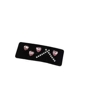 Elegant black acetate hair clip featuring four pink hearts and sparkling rhinestones