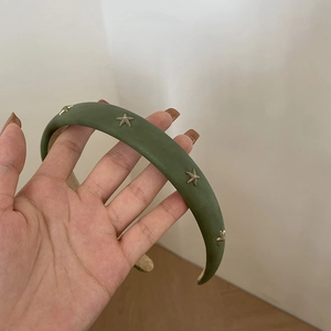 Detail of olive green padded leather headband with golden starfish metal ornaments