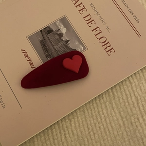 Fermaglio per capelli in velluto rosso vino con cuore rosso su un libro d'epoca