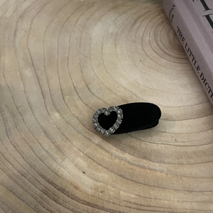 Elegant black velvet hair clip with rhinestone heart on rustic wooden tray