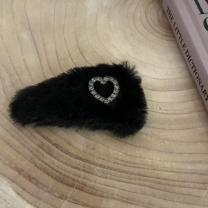 Elegant black velvet hair claw clip with sparkling rhinestone heart on wooden surface