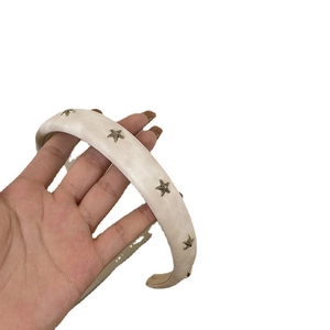 Chic padded off-white headband with golden starfish metal accents for elegant hair styling