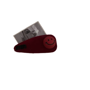Fermaglio per capelli in peluche rosso con ricamo nero e un simpatico bottone smiley