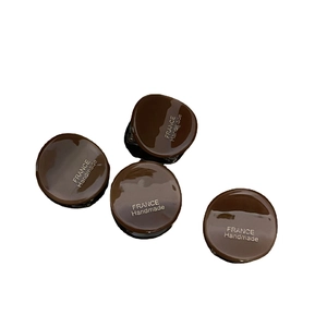 Set of four small dark brown acetate hair clips with gold label and smooth glossy finish