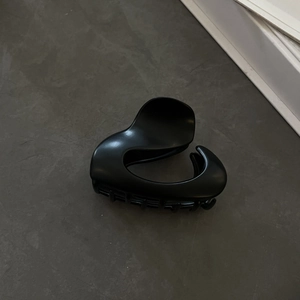 Detail view of the matte black heart-shaped hair claw clip with sturdy grip teeth