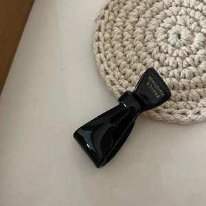 Dettaglio del fermaglio a fiocco nero con scritta dorata France Handmade incisa
