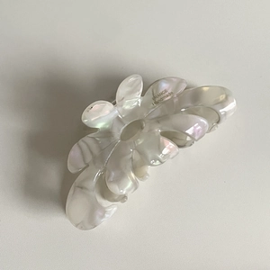 Dettaglio del fermaglio per capelli a fiore in acetato con finitura in madreperla lucida