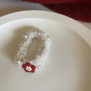 Detail of white plush hair scrunchie with faux pearls and cute rabbit floral pendant