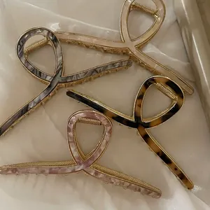 Set of four elegant bow-shaped metal hair claws in acetate finishes on silk fabric
