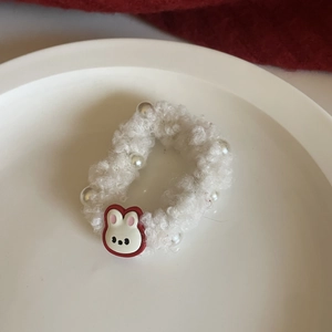 Detail of plush white fleece hair tie with cute rabbit charm and glossy pearls