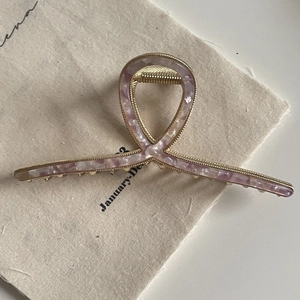 Elegant oversized gold metal hair claw clip with pink marble acetate bow design