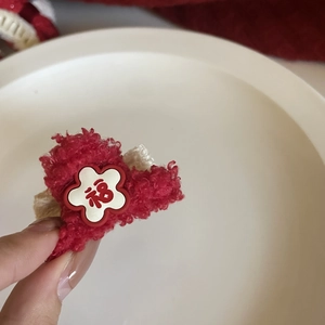 Close-up of red plush heart hair clip with white Fu character plum blossom detail