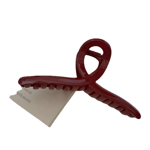 Deep red high-gloss shark clip hair claw with elegant twisted design and strong metal spring