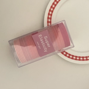 Macro shot of high elasticity candy pink hair tie set in a clear storage container