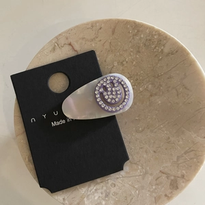 Elegant teardrop hair clip with purple rhinestone smiley face and white pearl base