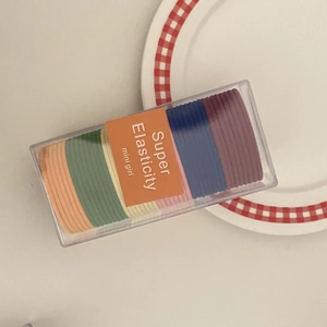 Detail of multi-colored high-elasticity hair ties set in a clear plastic box packaging