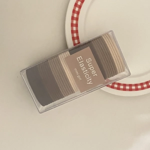 Detail of multi-color elastic hair ties in a transparent box with minimalist packaging