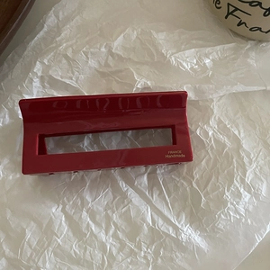 Detail of red rectangular hair claw with gold France Handmade engraved text