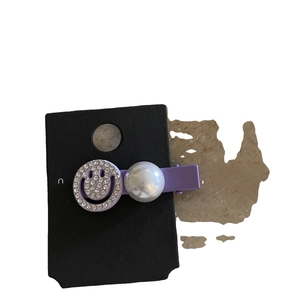 Elegant purple rhinestone hair clip with smiling face and pearl on display card