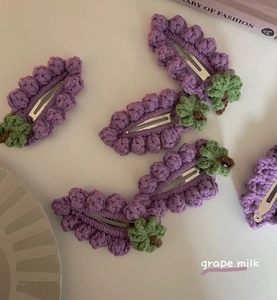 Détail de cinq barrettes à cheveux en crochet faites main en forme de raisins violets