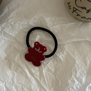 Detail of red acrylic bear hair tie with inlaid rhinestones and France Handmade text