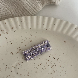 Fermaglio per capelli a quadri viola e bianchi con paillettes su vassoio