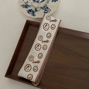 Floral smile print skinny silk scarf for hair and bag styling on wooden tray