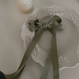 French style grass green satin bow hair clip with long ribbons on a white lace plate