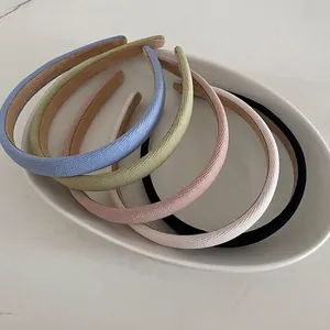 Set of five colorful twill fabric headbands in macaron tones on a ceramic plate
