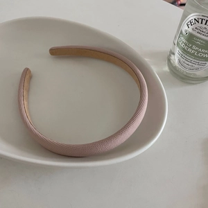 Chic pink macaron fabric headband displayed in a white ceramic dish for stylish women