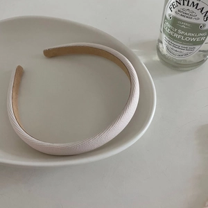 Minimalist macaron colored twill headband in soft fabric finish on a white decorative plate