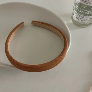 Detail of caramel twill fabric headband displayed on a white ceramic plate decoration