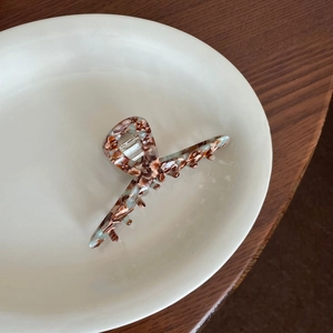 Brown and blue marble texture acetate hair claw clip on a white ceramic plate