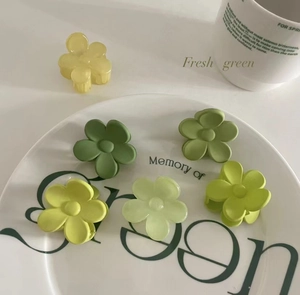 Gros plan de pinces à cheveux fleurs givrées vertes pour un style frais et élégant