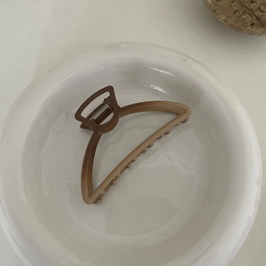 Vue détaillée d'une grande pince à cheveux mate dégradé marron sur assiette blanche