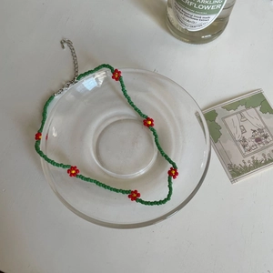 Collier artisanal en perles vert menthe avec marguerites colorées et fermoir mousqueton