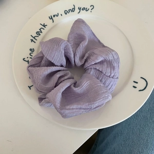 French style macaron purple pleated hair scrunchie in a white ceramic plate