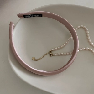 Serre-tête élégant en satin rose avec étiquette fait main sur une assiette en céramique