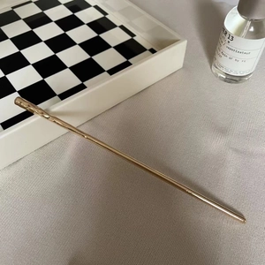 Minimalist gold hair pin with hammered texture design for modern bun hairstyles