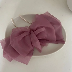 Detail view of large dusty pink double-layered mesh bow hair clip on ceramic tray