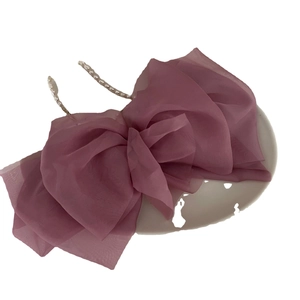 Elegant dusty rose double-layer tulle bow hair clip with faux pearl strings on a white plate