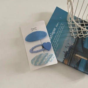 Detailed view of 3-piece blue fabric and heart-shaped hair clip set on a white card