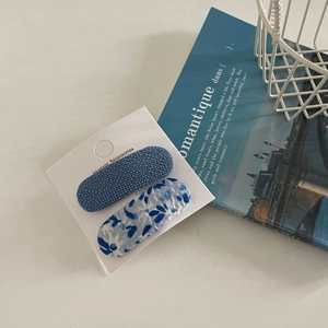 Blue fabric hair clip set with floral and textured patterns on a white display card