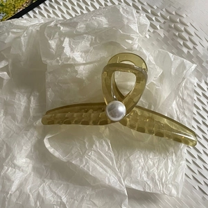 Minimalist olive green hair claw clip with a large white pearl on white background