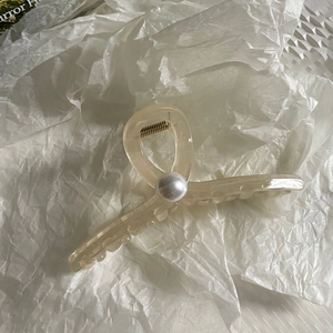 Elegant cream resin hair claw clip with large pearl detail and golden metal spring