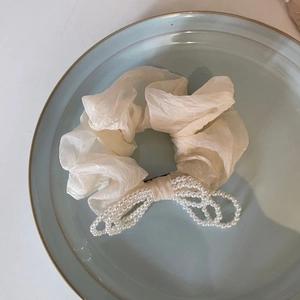 Elegante elastico per capelli in organza beige con fiocco di perle su piatto blu