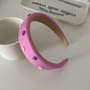 Pink padded sponge headband with handmade purple beaded flower decor in vintage style