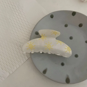 Large cream hair claw clip with yellow sun flower patterns and secure interlocking teeth
